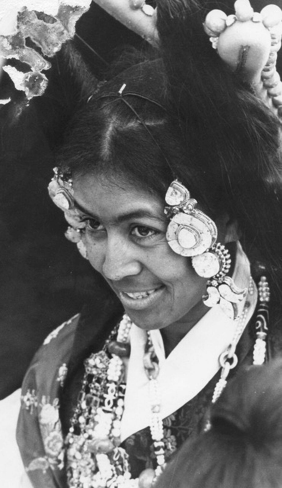 black and white photo of sister max, smiling and adorned with traditional jewelry