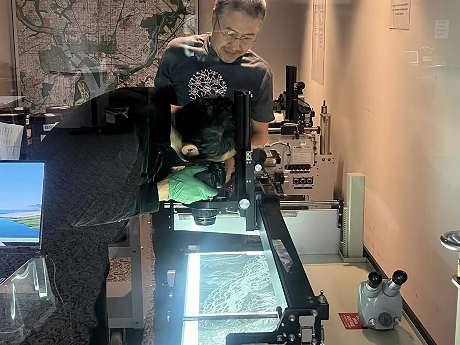 two people scanning U-2 film with gloves on