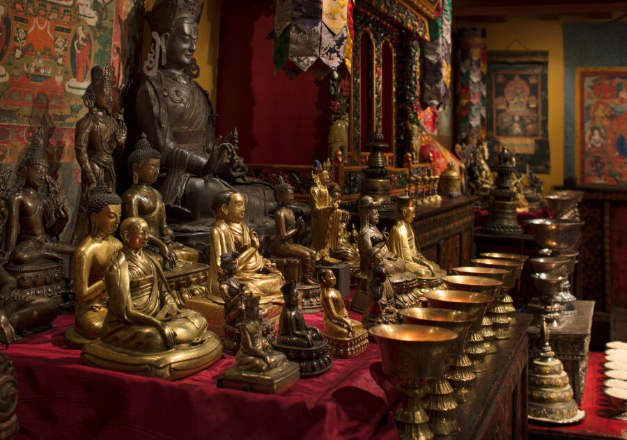 detail of the Rubin Museum Tibetan Buddhist Shrine Room with butter lamps, sculptures, and tsa tsas