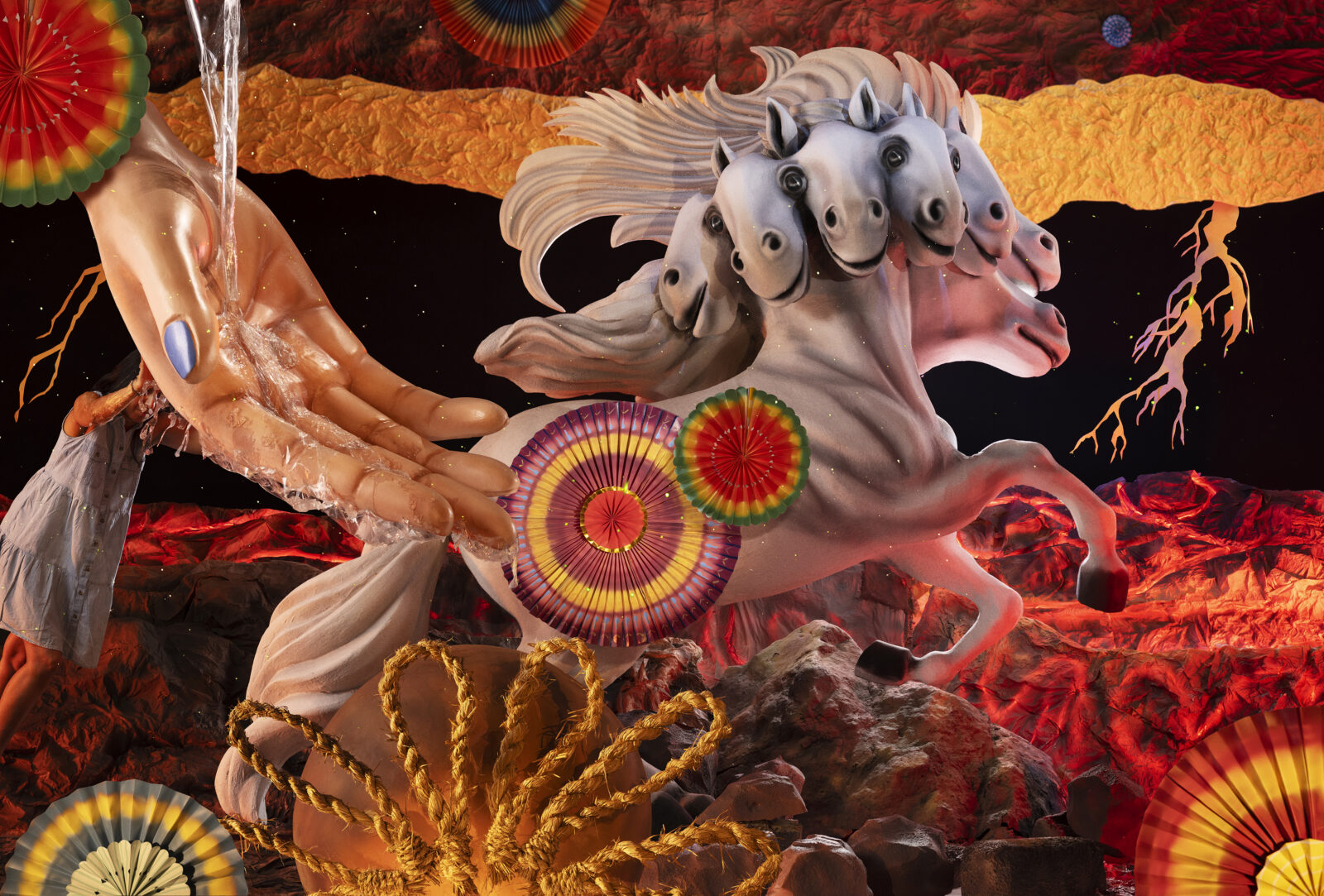 A collage of a seven-headed horse, a hand catching falling water, circular color shapes, and a figure wearing a dress on top of a red, yellow, and black background
