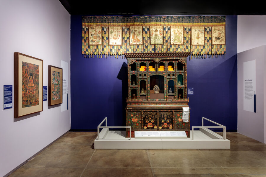 A cabinet on a white platform in front of a purple wall
